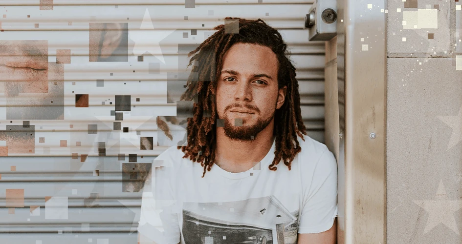 Junger Mann mit Bart und schulterlangen Locks, der in die Kamera blickt.